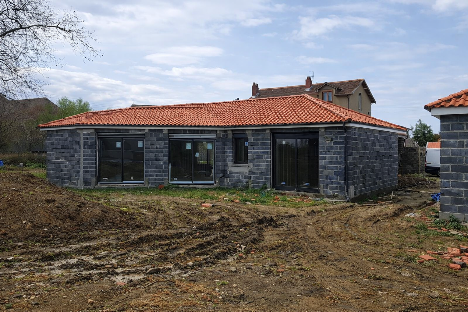 Travaux de rénovation de toiture sur une maison avec couverture en tuiles.